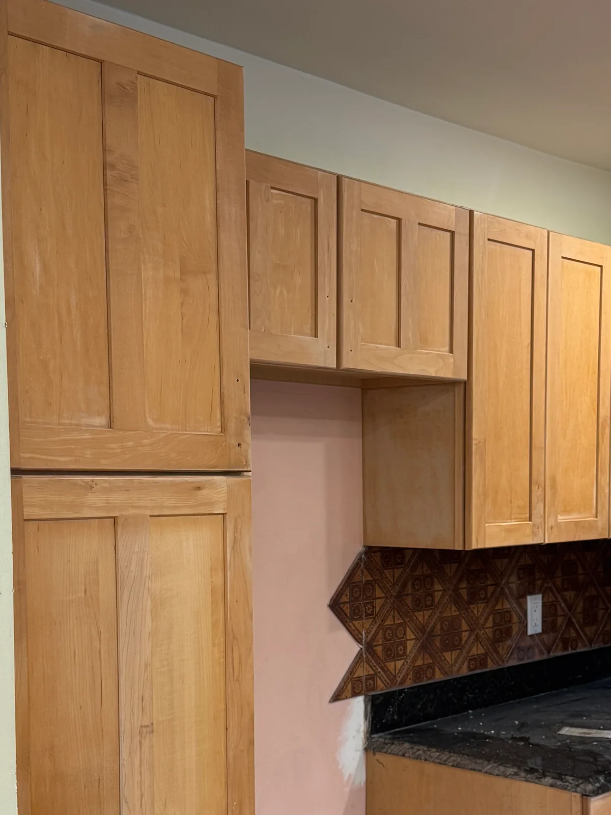 Kitchen cabinets in natural wood tone before refinishing
