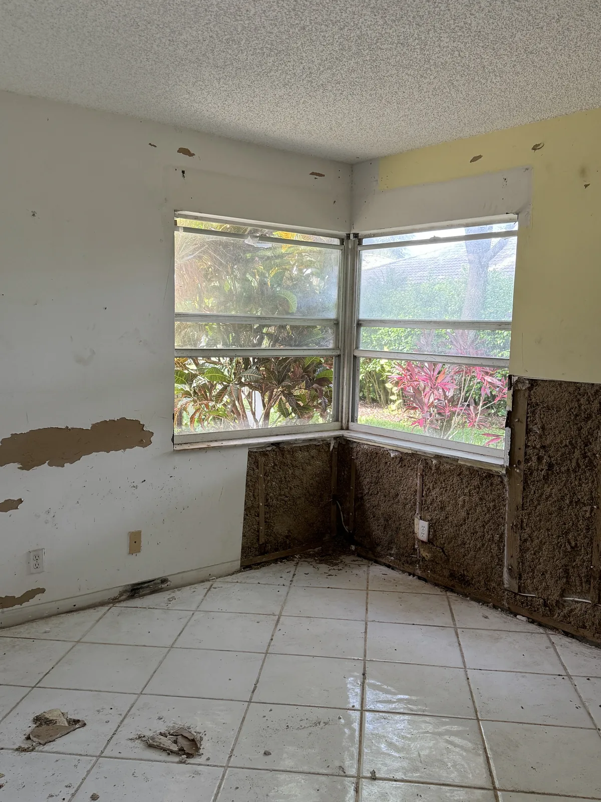 Room with popcorn ceiling and water-damaged walls before repair
