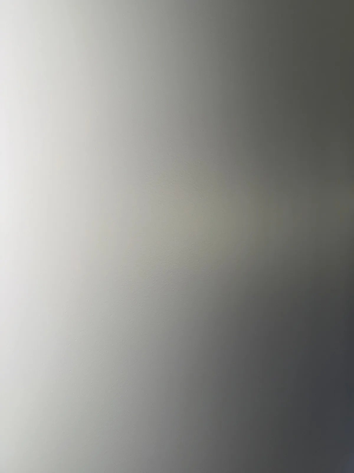 Close-up of the same wall after skim coat, smooth, paint-ready finish